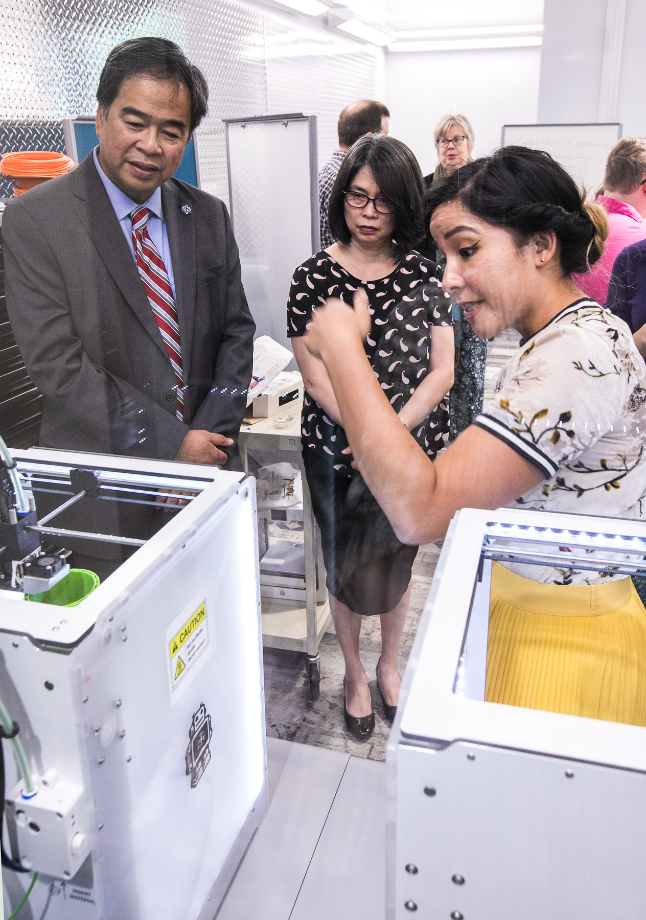 Janice Scurio, right, shows off one of the 3D printers available in the new maker space to DePaul University President A. Gabriel Esteban, Ph.D., and his wife, Josephine, as they tour the newly workspaces in the Richardson Library. (DePaul University/Jamie Moncrief)